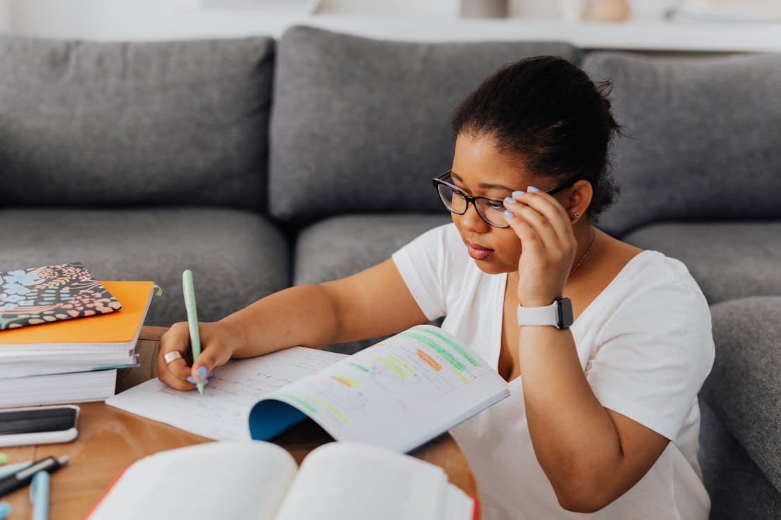 student using notes and textbooks to prepare for finals in a focused home study session