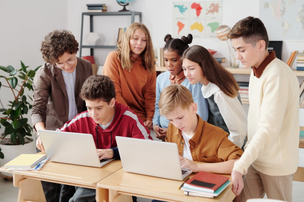 students using technology in the classroom with laptops during a teacher-guided lesson