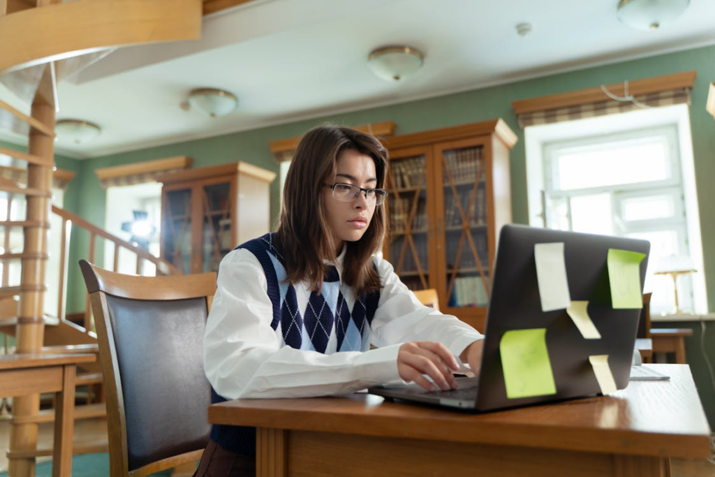 student trying to catch up in school while working on assignments at a laptop